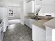 Bright kitchen features white cabinets, stainless steel sink, and a view into the adjacent living area at 10827 Azure Valley Pl, Charlotte, NC 28269