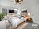Inviting primary bedroom features a ceiling fan and ample natural light from the windows at 10827 Azure Valley Pl, Charlotte, NC 28269