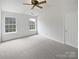 Bright bedroom with neutral carpet and natural light streaming through two large windows at 10827 Azure Valley Pl, Charlotte, NC 28269