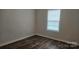 This bedroom features wood-look flooring and a window with white trim, creating a bright and modern feel at 1124 Clouse St, Gastonia, NC 28052