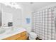 Clean bathroom features a vanity with wood cabinets, a toilet, and a shower with a white and black shower curtain at 11308 Morgan Valley Ln, Charlotte, NC 28270