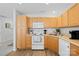 Well-lit kitchen featuring wooden cabinets, white appliances, and neutral countertops at 11308 Morgan Valley Ln, Charlotte, NC 28270