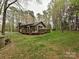 Ranch style home with a large deck and a well-maintained lawn surrounded by mature trees at 119 Dills Dr, Dallas, NC 28034