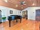 A spacious living room with a grand piano, hardwood floors, and a unique wooden ceiling design at 119 Dills Dr, Dallas, NC 28034