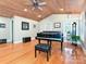 This living room features a grand piano, hardwood floors, and a ceiling fan with decorative wooden trim at 119 Dills Dr, Dallas, NC 28034
