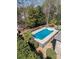Aerial view showcases a sparkling in-ground pool and patio set enclosed by black wrought iron fence at 124 Cedar Woods Dr, Mooresville, NC 28117