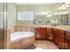 Bathroom with a corner tub, glass shower, double sinks, and neutral tile at 124 Cedar Woods Dr, Mooresville, NC 28117