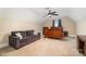 Large bedroom with a ceiling fan, a plush sofa, dark-stained furniture, and natural light from the window at 124 Cedar Woods Dr, Mooresville, NC 28117