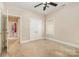 Bedroom view featuring a ceiling fan, window, and white double doors, with an open doorway to a hallway at 124 Cedar Woods Dr, Mooresville, NC 28117