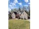 Attractive brick home featuring a well-maintained lawn and mature landscaping at 124 Cedar Woods Dr, Mooresville, NC 28117