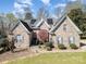 Beautiful brick home with manicured lawn, mature landscaping, and solar panels on a sunny day at 124 Cedar Woods Dr, Mooresville, NC 28117