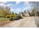 Spacious yard with long driveway leading up to a stately brick home at 124 Cedar Woods Dr, Mooresville, NC 28117