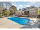 Stunning backyard pool with solar panels on brick home and a spacious wooden deck, perfect for relaxation at 124 Cedar Woods Dr, Mooresville, NC 28117