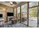 Sunroom with exposed brick fireplace, TV, ceiling fan, area rug, and access to the backyard pool at 124 Cedar Woods Dr, Mooresville, NC 28117