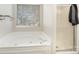Bright bathroom featuring a relaxing soaking tub next to a glass shower with silver hardware at 14525 Arbor Ridge Dr, Charlotte, NC 28273