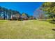 Spacious backyard with mature trees and a beautiful brick home in the background at 1515 Paul Boyd Rd, Clover, SC 29710