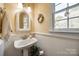 Charming bathroom featuring a pedestal sink, wainscoting, and a decorative mirror at 1515 Paul Boyd Rd, Clover, SC 29710