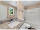 Bathroom with granite vanity top, framed mirror and tub with shower and white tile surround at 1587 Green Circle Dr, Gastonia, NC 28054