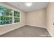 This inviting bedroom is filled with neutral walls, plush carpeting, and one large window offering ample natural light at 1587 Green Circle Dr, Gastonia, NC 28054