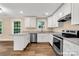 Charming kitchen features white cabinets, stainless steel appliances, and granite countertops at 1587 Green Circle Dr, Gastonia, NC 28054