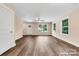 Bright living room with tan walls, wood-look floors, and natural light from three large windows at 1587 Green Circle Dr, Gastonia, NC 28054