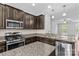 Open kitchen featuring stainless steel appliances, granite countertops, and dark cabinetry at 19737 Playwrights Way, Cornelius, NC 28031
