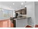 Kitchen with island, breakfast bar, stainless appliances, and wood floors at 19737 Playwrights Way, Cornelius, NC 28031