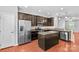 Open kitchen with island, stainless appliances, and dark cabinetry at 19737 Playwrights Way, Cornelius, NC 28031