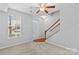 Cozy living room area featuring a staircase, window and neutral carpet at 19737 Playwrights Way, Cornelius, NC 28031