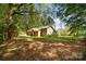 Expansive backyard showcasing the home's exterior, a wooden playset, and privacy fencing at 2014 Cardinal Loop, Stanley, NC 28164