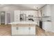 The kitchen boasts white cabinets, granite countertops, stainless steel appliances, and a large kitchen island at 2014 Cardinal Loop, Stanley, NC 28164