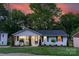 Charming single-story home with well-manicured lawn and inviting front porch at dusk at 215 Wyanoke Ave, Charlotte, NC 28205