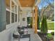 Covered porch featuring comfortable seating, wood columns, and a view of the landscaped front yard at 215 Wyanoke Ave, Charlotte, NC 28205