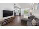 Bright living room with a comfortable couch, sleek entertainment center, and an open view into the kitchen at 2403 Earley Cir, Kannapolis, NC 28083