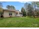 Large backyard with a deck, patio with a fire pit, and mature trees at 2587 Penngate Dr, Sherrills Ford, NC 28673