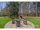 Backyard patio features a charming fire pit area surrounded by mature trees for serene outdoor living at 2587 Penngate Dr, Sherrills Ford, NC 28673