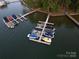 Aerial view showcasing multiple covered boats at private docks on the serene open water at 2587 Penngate Dr, Sherrills Ford, NC 28673