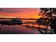 Waterfront home featuring a dock and boat slips with vibrant sunset views over the lake at 2587 Penngate Dr, Sherrills Ford, NC 28673
