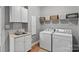 Laundry room with updated machines, overhead cabinets, and sink with cabinet storage at 2587 Penngate Dr, Sherrills Ford, NC 28673