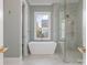 Stylish bathroom with a freestanding tub and glass shower, complemented by neutral tones and a bright window at 2924 Sharon View Rd # C, Charlotte, NC 28210