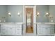 Dual sink bathroom with modern fixtures, white cabinetry, and a doorway leading to an adjoining space at 2924 Sharon View Rd # C, Charlotte, NC 28210