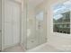 Contemporary bathroom with a glass-enclosed shower, built-in storage, and a window providing natural light and an outside view at 2924 Sharon View Rd # C, Charlotte, NC 28210