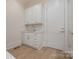 A laundry room with white cabinets, a white sink, and light wood flooring at 2924 Sharon View Rd # C, Charlotte, NC 28210