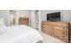 Bright bedroom with wooden dressers, white linens, and a doorway to another room at 3111 Everly Enclave Way, Charlotte, NC 28210