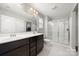 Bright bathroom with double sinks, large mirror, and walk-in shower with glass doors at 4006 Stockbrook Dr, Charlotte, NC 28215