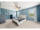 Blue main bedroom with carpet, fan, and natural light from two large windows at 4006 Stockbrook Dr, Charlotte, NC 28215