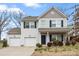 Charming two-story home featuring a two-car garage, blue shutters, and a welcoming front porch at 4006 Stockbrook Dr, Charlotte, NC 28215