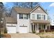 Charming two-story home with two-car garage, light siding, blue shutters and well-maintained landscaping at 4006 Stockbrook Dr, Charlotte, NC 28215