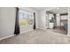 Cozy living room with large windows adjacent to a kitchen with stainless steel appliances at 4006 Stockbrook Dr, Charlotte, NC 28215
