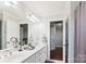 Bright bathroom featuring double sinks and view to hallway with wood floors at 420 Woodlark Ct, Indian Trail, NC 28079